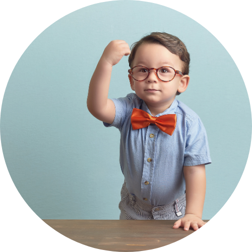 蝶ネクタイをつけてメガネをかけた男の子がガッツポーズしている画像