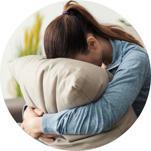 クッションに顔をうずめている女性