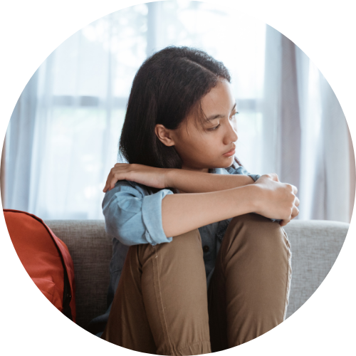 ソファーの上に膝を抱えて座っている少女