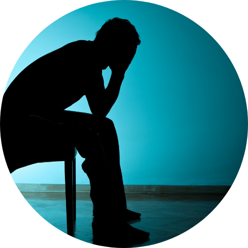 頭を抱えてイスに座っている人のシルエット