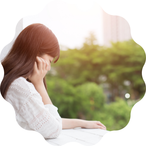 窓辺で頬杖ついている女性の横姿