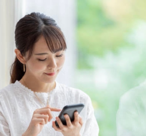 ネットでエアコンクリーニングを検索している女性