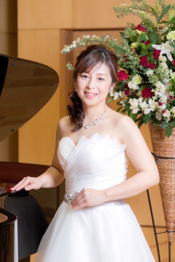 白いドレスを着たピアノ講師の写真