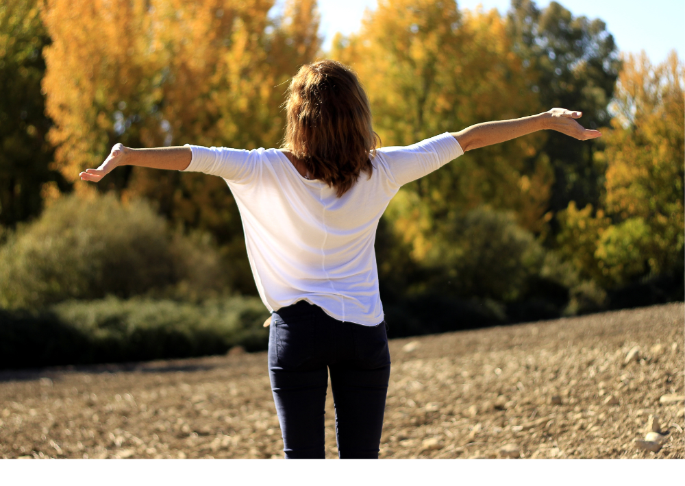 秋の公園で人が手を伸ばしている姿