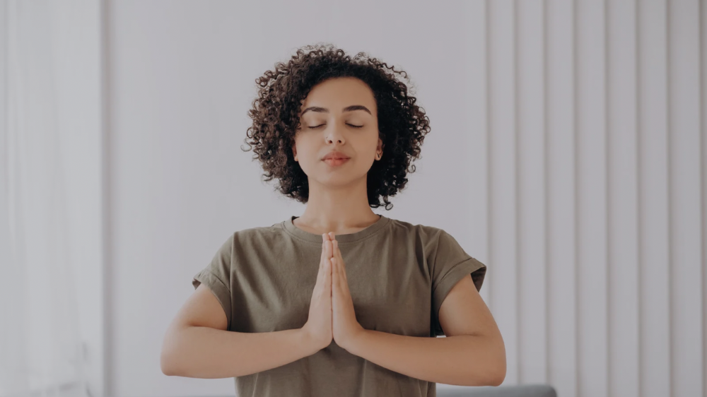 手を胸の前で合わせている人