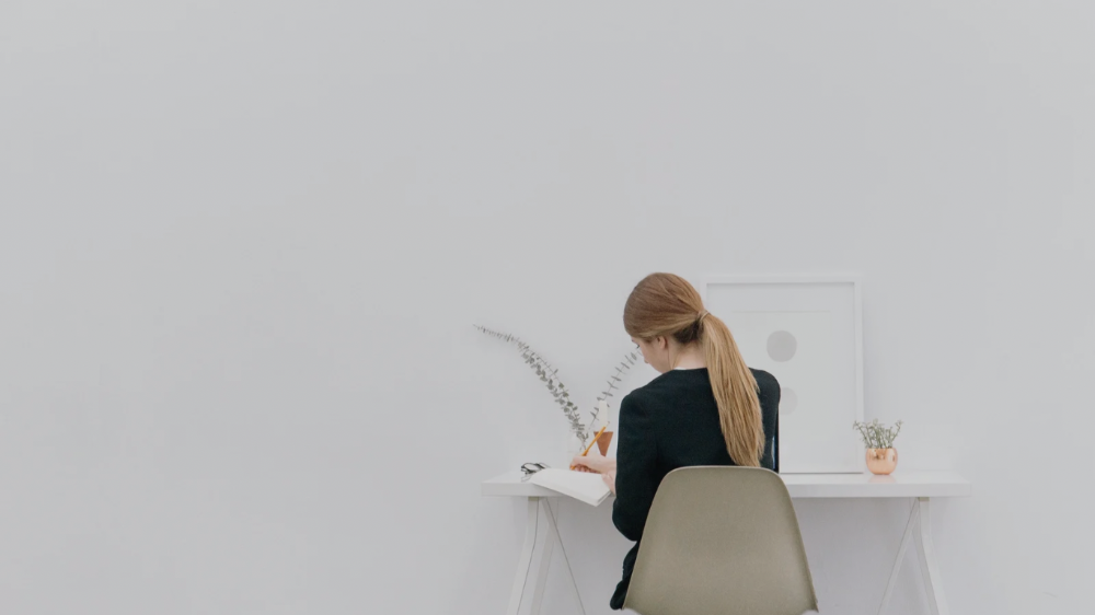 デスクに座っている人の後ろ姿