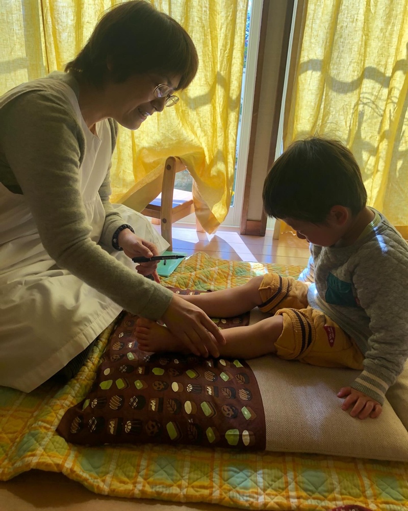 助産師さんに小さい子がお灸をしてもらっている