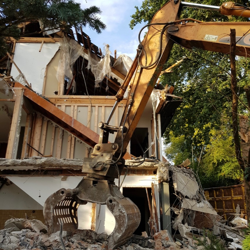 ショベルカーに乗って工事する作業員