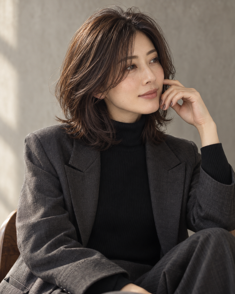 ダークブラウンのレイヤーヘアと落ち着いたネイルのイメージ