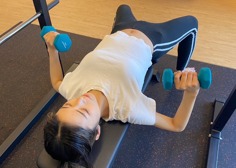 パーソナルトレーニング(ダンベルを使って運動する女性)