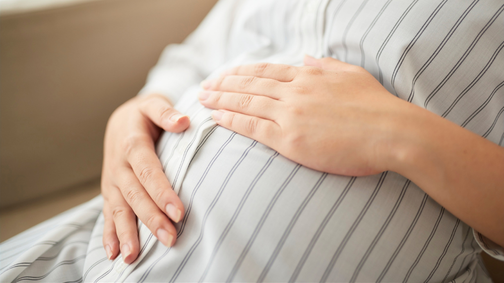 妊婦さんがお腹に手を当てている姿