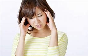 頭痛でつらくて悩み、頭を押さえる女性